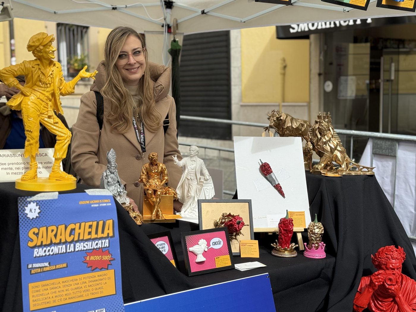 Mariassunta Telesca al suo stand a Lucania is Comics, accanto alla statua di Sarachella