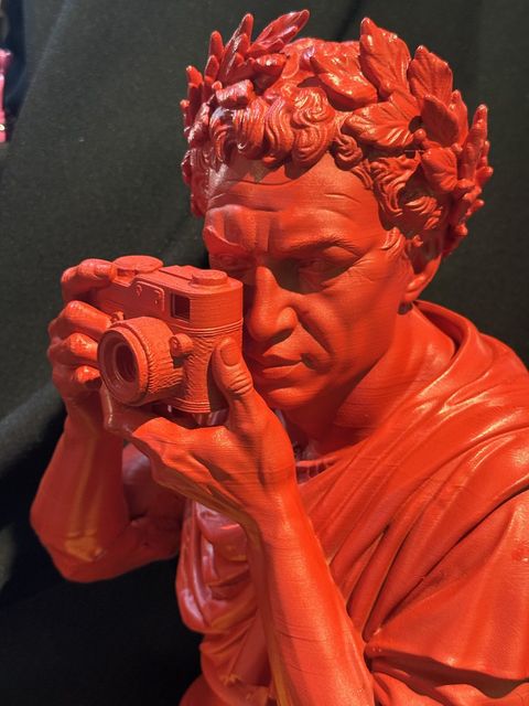 Orazio · Carpe Diem, busto rosso del poeta coronato d'alloro che scatta una fotografia